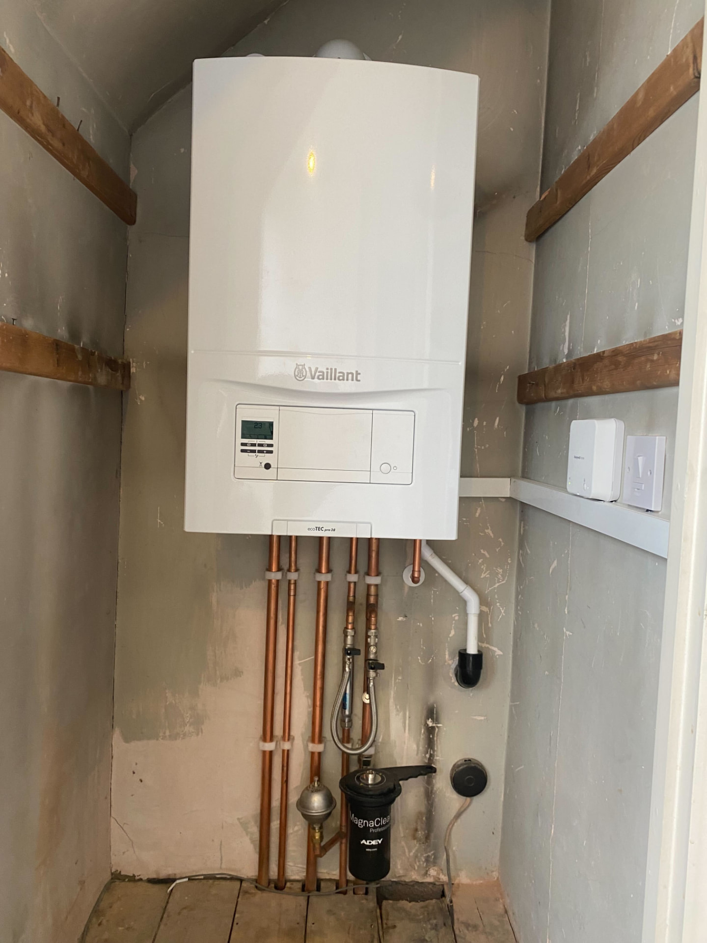 Vaillant system boiler installed in a cupboard with vertical copper pipework