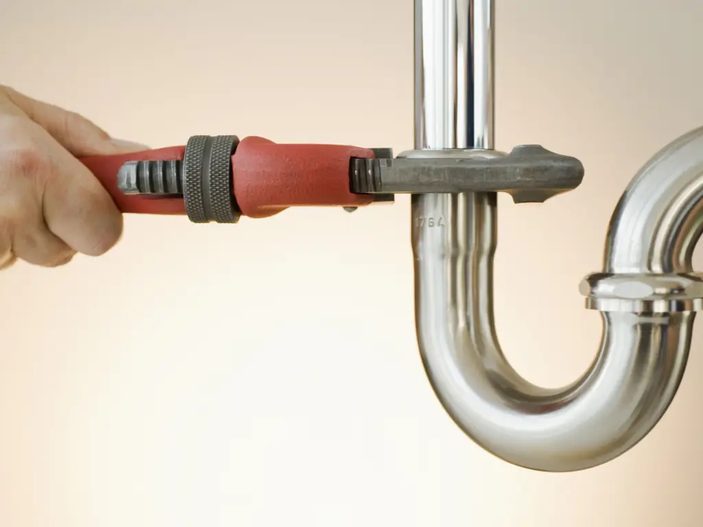 Plumber working on faulty pipes at property