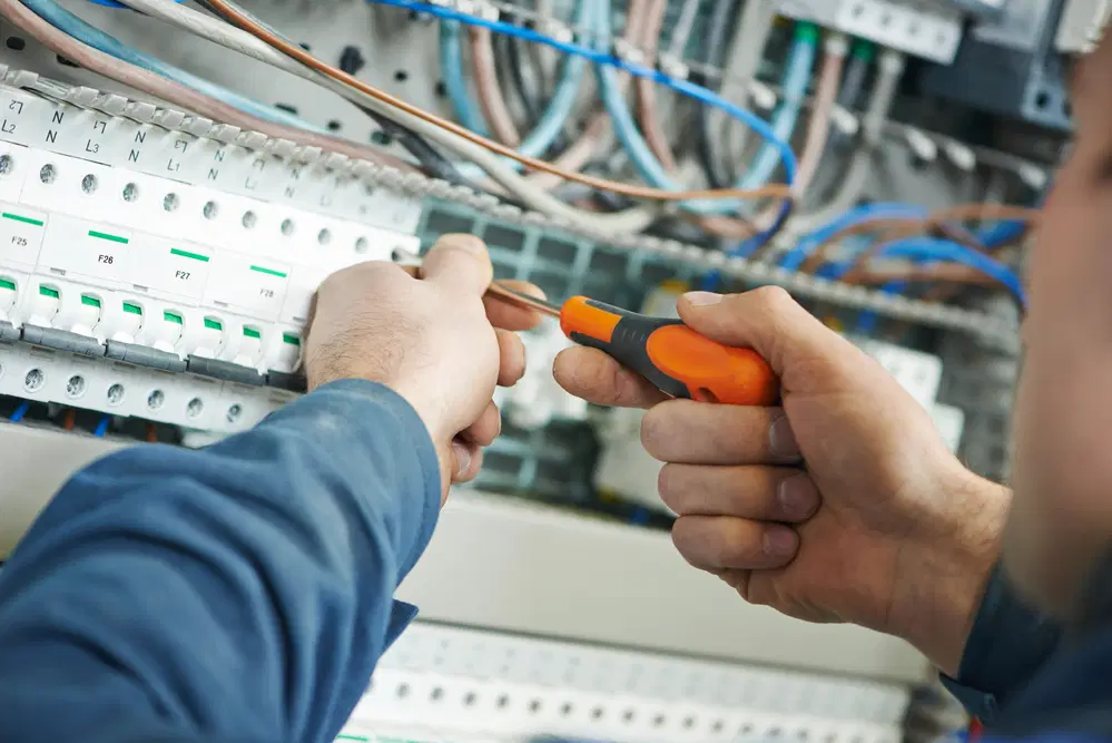 Electrician working on electrical unit