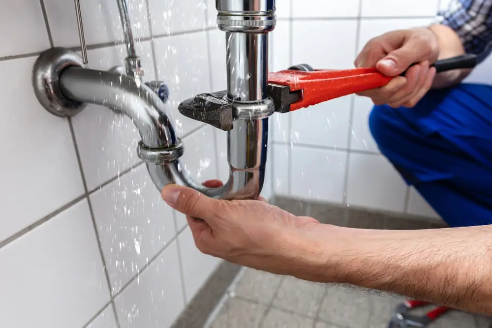 Plumber working on burst pipes at domestic property