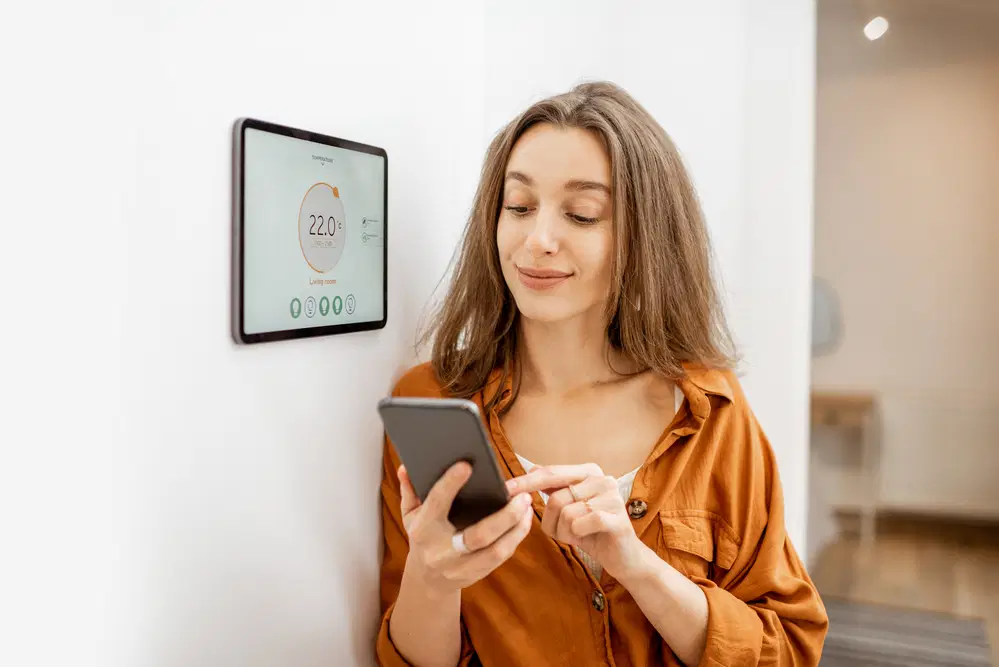 Happy woman controlling smart home system via her phone